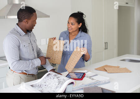 Couple examining fabric swatches in new home Banque D'Images