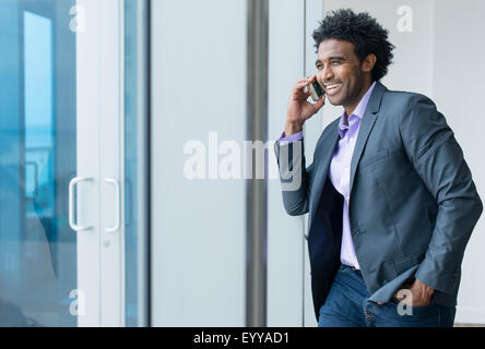 Hispanic businessman talking on cell phone in office Banque D'Images