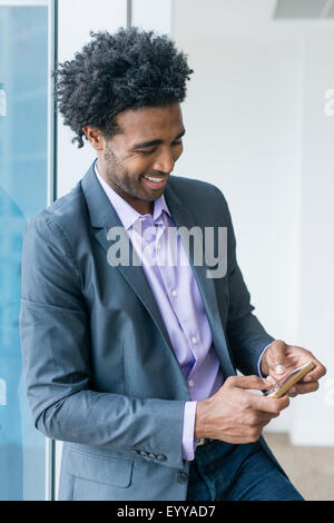 Hispanic businessman using cell phone in office Banque D'Images