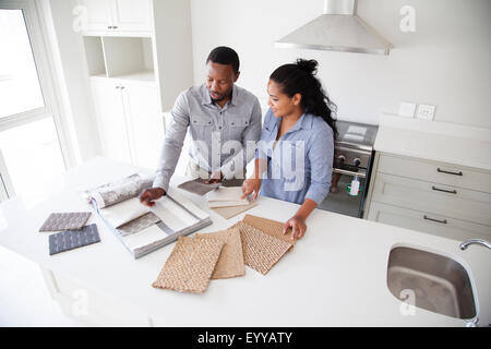 Couple examining fabric swatches in new home Banque D'Images