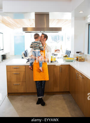 Woman kissing daughter in kitchen Banque D'Images