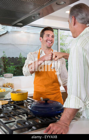 Portrait père et fils fist-choc dans la cuisine Banque D'Images