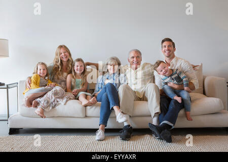 Caucasian multi-generation family sitting on sofa in living room Banque D'Images