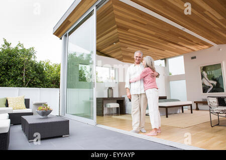 Caucasian couple hugging on porch Banque D'Images