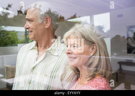 Caucasian couple looking out window Banque D'Images