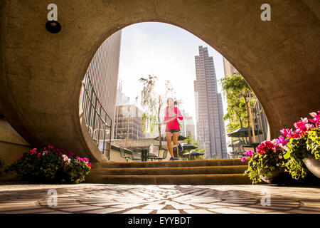 Woman running in urban park Banque D'Images