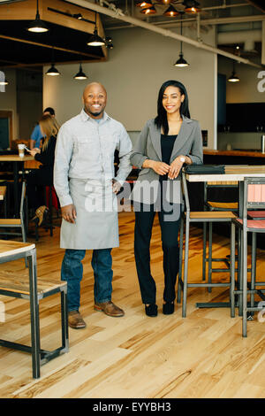 Serveur et businesswoman smiling in cafe Banque D'Images