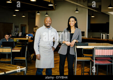 Serveur et businesswoman smiling in cafe Banque D'Images