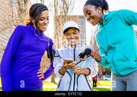 Porteur using cell phone in urban park Banque D'Images