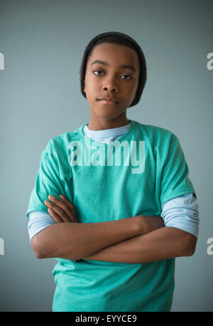 Noir élégant boy standing with arms crossed Banque D'Images