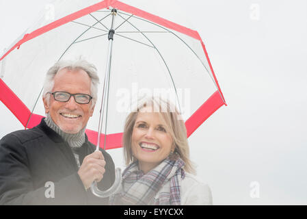 Older Caucasian woman under umbrella Banque D'Images