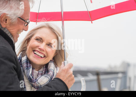 Older Caucasian woman under umbrella Banque D'Images