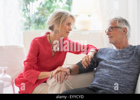 Caucasian couple talking in living room Banque D'Images