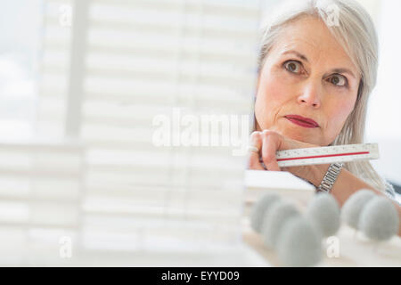 Caucasian architect examining scale model in office Banque D'Images