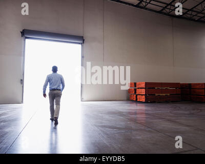 Caucasian businessman walking in warehouse Banque D'Images