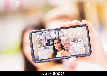 Close up of Hispanic couple en tenant l'extérieur selfies Banque D'Images