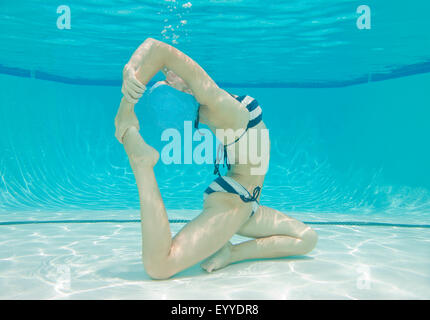 Sous-vue de Caucasian woman practicing yoga in swimming pool Banque D'Images