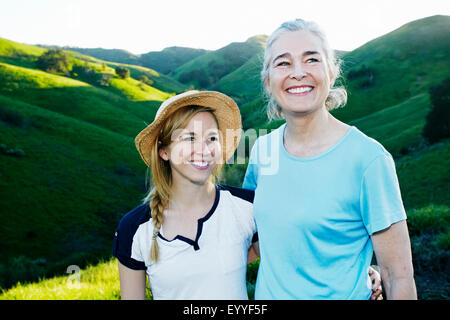 Caucasian mother and daughter smiling on rural hilltop Banque D'Images