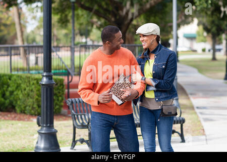 Smiling couple walking in urban park Banque D'Images