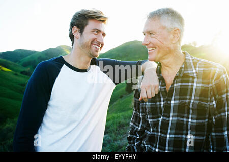 Caucasian father and son smiling on rural hilltop Banque D'Images