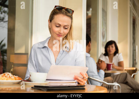 Businesswoman using digital tablet in cafe Banque D'Images