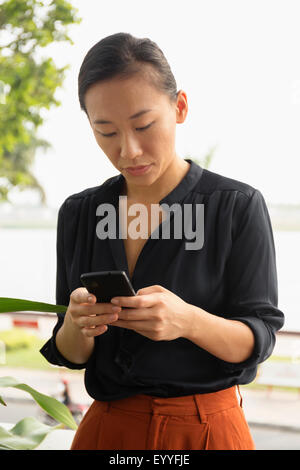 Asian businesswoman using cell phone Banque D'Images