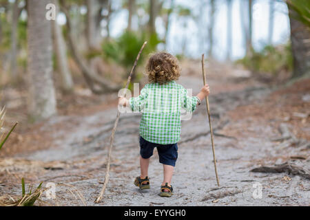 Caucasian baby boy walking on dirt path Banque D'Images