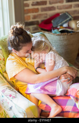 Caucasian mother holding daughter in armchair Banque D'Images