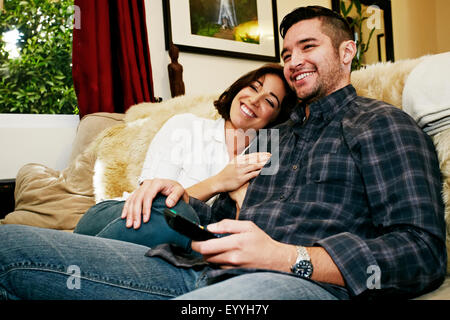 Couple relaxing on sofa in living room Banque D'Images