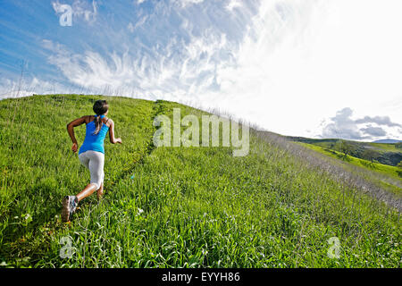 L'athlète noir running on rural hillside Banque D'Images