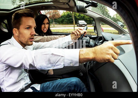 Jeune femme avec voiture conduite homme gesticulant comme co-pilote, Autriche Banque D'Images