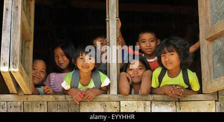 Les filles et les garçons du peuple Ifugao regardant par une fenêtre, Philippines, Luzon, Patpat Banque D'Images