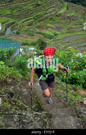 Touristique avec des bâtons de marche nordique Randonnée dans les escaliers à travers les terrasses de riz de Batad, Philippines, Luzon, Batad Banque D'Images