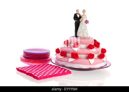 Couple sur le dessus de gâteau de mariage rose avec roses rouges isolated over white background Banque D'Images