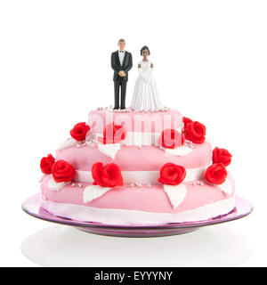 Couple mixte sur le dessus de gâteau de mariage rose avec roses rouges isolated over white background Banque D'Images