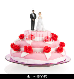 Couple mixte sur le dessus de gâteau de mariage rose avec roses rouges isolated over white background Banque D'Images