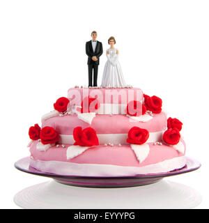 Gâteau de mariage rose avec des roses rouges et deux sur le dessus Banque D'Images