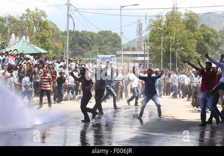 Srinagar, au Cachemire sous contrôle indien. 5 Août, 2015. Gouvernement du Cachemire crier des slogans comme enseignants police indienne pulvériser de l'eau sur eux au cours d'une manifestation à Srinagar, capitale d'été du Cachemire sous contrôle indien, le 5 août 2015. La police a utilisé les cannes et a tiré des dizaines d'obus lacrymogènes pour disperser des centaines d'enseignants du gouvernement du Cachemire au cours d'une manifestation contre la décision du gouvernement quant à la réalisation d'un test de dépistage d'enseignants dans le cadre des réformes de l'éducation dans le Cachemire sous contrôle. Credit : Javed Dar/Xinhua/Alamy Live News Banque D'Images