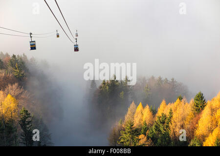 Chemin de câble vient du soleil sur le sommet de la brume dans la vallée, Allemagne, Bavière, Hohenaschau, Kampenwand Banque D'Images