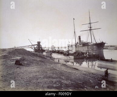 Canal de Suez, Egypte - 1870 - dragage du canal. En prenant 10 ans pour construire le canal de Suez, a été conçu par le français Ferdinand de Lesseps, qui devint le président du Canal Maritime de Suez (Compagnie du Canal de Suez). La partie officielle a duré 10 jours. Un compte par Thos. H. Reid en 1909 : ÒThe cérémonie d'ouverture a été faite une magnifique fonction internationale. Une maison d'opéra a été bâti au Caire pour un coût de 60 000 livres sterling. Verdi, le compositeur, a écrit l'opéra égyptien ÒAidaÓ pour l'occasion, et pas de la composition est plus populaire au cours de la saison du Caire aujourd'hui. Banque D'Images