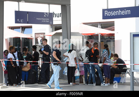 Rosenheim, Allemagne. Le 04 août, 2015. Un groupe de réfugiés de différents pays en attente d'être enregistré est situé sur une plate-forme à la gare de Rosenheim, Allemagne, 04 août 2015. La police allemande a ramassé autour de 150 réfugiés de différents pays dans un train entrant de Vérone. Après avoir été fouillé et enregistrés, ils ont reçu un document d'identification à un bureau de la Police Fédérale Allemande et a été envoyé à l'établissement d'accueil des réfugiés à Munich, où ils peuvent faire une demande d'asile. Photo : Andreas GEBERT/dpa/Alamy Live News Banque D'Images