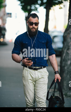 Homme barbu va et écoute de la musique Banque D'Images