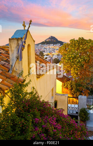 Vue sur le mont Lycabette et une petite église orthodoxe grecque à l'Anafiotika, Athènes. Banque D'Images