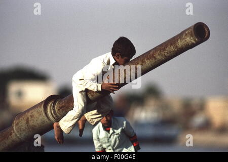 Canal de Suez, Egypte - les enfants égyptiens jouer sur les ruines d'un réservoir à l'extrémité sud du Canal de Suez, témoins de guerres passées entre l'Égypte et Israël. Le canal de Suez a été fermé à la navigation à partir de 1967 jusqu'à la fin des années 1970, en raison de débris de navires coulés dans le canal. Une des merveilles du génie construit en 1869 par le français Ferdinand de Lesseps, elle est aujourd'hui l'objet d'une mise à niveau importante par l'ajout d'un canal parallèle pour augmenter le trafic et de réduire les temps d'attente. Banque D'Images