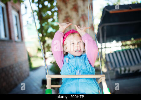 Laughing little girl on swing Banque D'Images