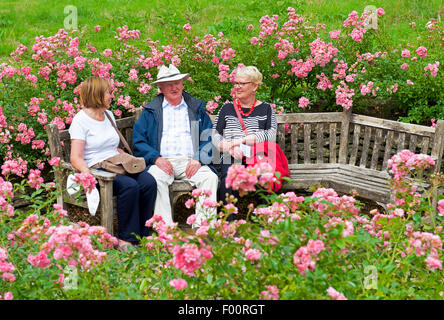 Les visiteurs assis sur un banc dans les jardins de Great Chalfield Manor, une propriété du National Trust à proximité de Melksham, Wiltshire, Angleterre Banque D'Images