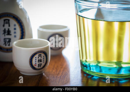 Une bouteille de saké japonais, d'alcool brassée par la brasserie de saké Gekkeikan Kyoto, avec tasses de saké en céramique portant le logo de l'entreprise. Banque D'Images