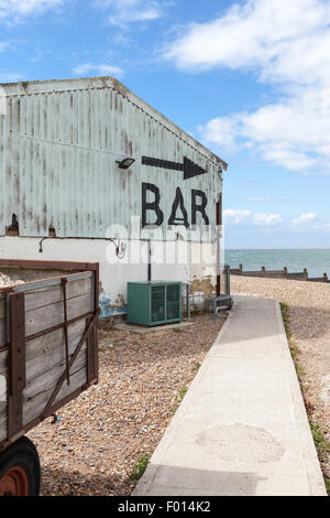 Flèche et signe pour le bar en soulignant à la mer, sur la plage de Whitstable, Kent, UK Banque D'Images