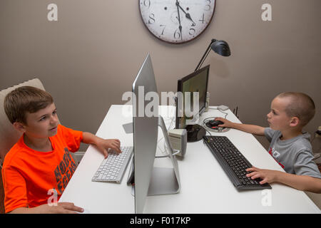 Deux frères, neuf et sept ans, jouer à des jeux vidéo à la maison après l'école. M. Banque D'Images