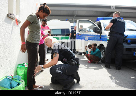 Rosenheim, Allemagne. Le 04 août, 2015. Ruth de l'Érythrée est fouillée par un agent de police Sandra Mitschker à la gare de Rosenheim, Allemagne, 04 août 2015. La police allemande a ramassé autour de 150 réfugiés de différents pays dans un train entrant de Vérone. Après avoir été fouillé et enregistrés, ils ont reçu un document d'identification à un bureau de la Police Fédérale Allemande et a été envoyé à l'établissement d'accueil des réfugiés à Munich, où ils peuvent faire une demande d'asile. Photo : Andreas GEBERT/dpa/Alamy Live News Banque D'Images